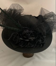 "VICTORIAN WIDE BRIM HAT - 1538 Ladies Black Edwardian Hat This style is our Wide Brim Black Edwardian hat with black flowers, tulle, lace covered crown, satin bow, ostrich plume and pheasant feathers. NOTE - MUST READ - The long pheasant feathers on the hat have a hint of green in them as seen in the picture of the front of the hat. If you don't want the pheasant feathers I can omit them. Please message me in the note to seller during checkout. SIZE: Medium, 22\" - 22 1/2\" inches for the head Black Wide Brim Hat, Edwardian Hat, Victorian Accessories, Steampunk Top Hat, Material Flowers, Victorian Hats, Victorian Costume, Tea Party Hats, Pheasant Feathers