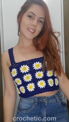 a woman with red hair wearing a blue and white crochet cropped top