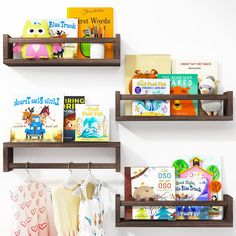 three wooden shelves with books and other children's books on them against a white wall