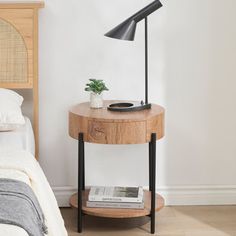 a bed room with a neatly made bed and a lamp on the nightstand next to it