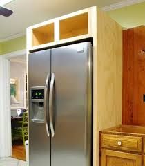 a stainless steel refrigerator freezer sitting in a kitchen next to a wooden cabinet with drawers