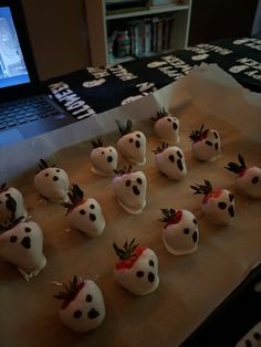 chocolate covered strawberries are arranged in front of a laptop on a table with the screen lit up