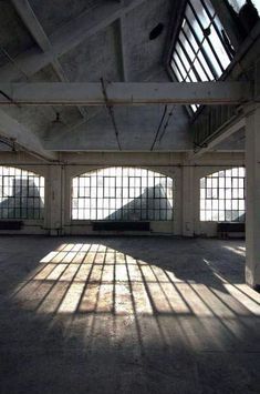 an empty warehouse with several windows and bars