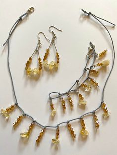 With these citrine amber accessories, create a chic delicate look in pale golden yellow and amber shades. The dangle earrings and necklace carry similar eye-catching allure with subtle glitter in the bracelet. The jewelry set includes a necklace, earrings, and a bracelet. Gemstone - Citrine Beads - Bicone faceted crystal glass beads Color - Pale yellow, amber Earring Style - Teardrop hoop Necklace and bracelet closure - Lobster claw Other materials - Gray beading thread, metal hoops, metal frenc Elegant Beaded Citrine Jewelry, Bohemian Amber Jewelry For Party, Adjustable Amber Citrine Necklace, Adjustable Beaded Citrine Jewelry, Adjustable Yellow Dangle Jewelry, Amber Citrine Dangle Jewelry, Adjustable Yellow Jewelry Sets For Gift, Adjustable Citrine Jewelry, Handmade Yellow Citrine Jewelry