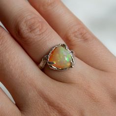 ☆This ring is handmade and one of a kind, no two rings will ever be the same. ☆Made from recycled sterling silver. ☆This ring was handcrafted and cast in silver in London, before being sent back to be set and finished. ☆Natural Ethiopian Opal sourced from India, each opal is unique in its own way. ☆This ring is a size is based around a K - however the design of the ring allows it to be adjustable to be smaller or bigger. ☆Unlock your inner ethereal essence with this one of a kind ring. ☆This ring is a creatively crafted piece - meaning it is not perfect and the shape and style is reflective of the art I created. ☆Non - refundable once purchased due to its unique nature, however if you are not happy with your ring you can exchange it. ☆All orders come beautifully wrapped with care instructi Unique Sterling Silver Opal Ring For Wedding, Unique Sterling Silver Opal Wedding Ring, Unique Hand Wrapped Opal Jewelry, Handmade Fusion Style Promise Ring, Unique Handmade Freeform Ring, Handmade Unique Sterling Silver Opal Ring, Sterling Silver Freeform Rings As Gifts, Handmade Silver Rings With Ethiopian Opal, Unique Handmade Open Opal Ring