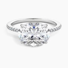 an oval cut diamond engagement ring with pave set shoulders