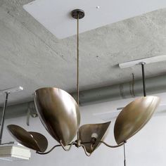 a chandelier hanging from the ceiling in a room with exposed ceilings and lights