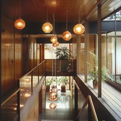 a hallway with lights hanging from the ceiling and potted plants on the floor below