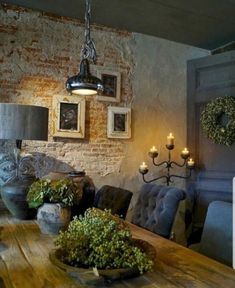 a wooden table topped with lots of green plants next to a wall mounted candle holder