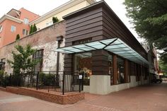 a store front with an awning on the outside and brick walkway leading up to it