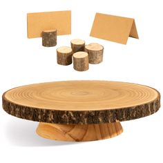 a wooden table topped with slices of wood next to post - it notes and cutouts