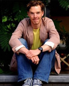 a man sitting on a bench with his legs crossed