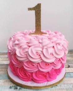 a pink and gold cake with a number one on top