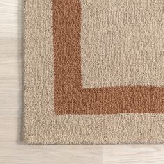 a brown and white rug on top of a wooden floor