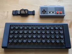 an old computer keyboard sitting on top of a wooden table next to a mouse and watch