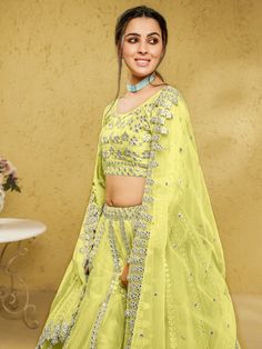 Introducing our captivating lime yellow foil work net engagement wear lehenga choli, a stunning ensemble that will make you the center of attention at any special occasion. This exquisite outfit features a lime yellow color net material lehenga with intricate foil work, complemented by a similar color net material choli also adorned with foil work. Complete your look with the included matching net dupatta, which features both foil work and beautiful lace work.
The lime yellow lehenga is semi-sti Yellow Organza Choli With Dori Work, Yellow Organza Sets With Dori Work, Yellow Organza Sets For Navratri, Yellow Organza Choli For Navratri, Navratri Yellow Organza Choli, Yellow Zari Work Party Wear Dupatta, Yellow Zari Work Party Dupatta, Eid Green Net Lehenga, Yellow Zari Work Dupatta For Party