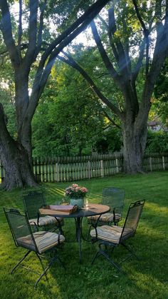 an outdoor table and chairs in the grass