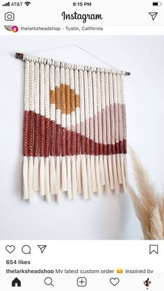 a wall hanging made out of white and red beads with a brown star on it