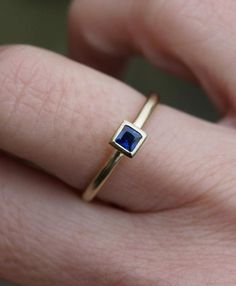 Small 3mm square dark blue sapphire is set in an 18ct gold  ring. This ring can be stacked with others and is also available with an emerald and a ruby or a diamond (extra cost).The band is 1.5mm round, so overall a delicate but solid ring. Made to order in your size. Orders take 3-4 weeks. Sapphires are the birthstone for Septemebr babies.For other stacking rings go to:www.etsy.com/shop/karenjohnsondesignor facebook.com/karenjohnsondesign Square Cut Sapphire Ring For Gift, Square Cut Sapphire Ring As Gift, Rectangular Sapphire Ring In Yellow Gold, Rectangular Blue Sapphire Ring In 14k Gold, Modern Sapphire Ring Birthstone, Sapphire Ring Gold, Gold Topaz Ring, White Topaz Engagement Ring, Garnet Ring Silver