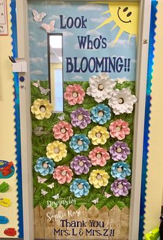 a door decorated with flowers and the words look who's blooming