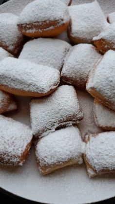 powdered sugar covered donuts on a plate