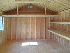 an empty room with wood paneling and windows