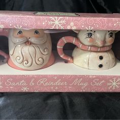 two ceramic santa and reindeer mugs in a pink box with snowflakes on it