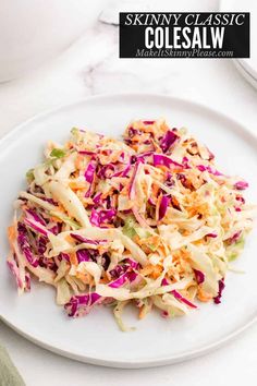 a white plate topped with coleslaw on top of a table