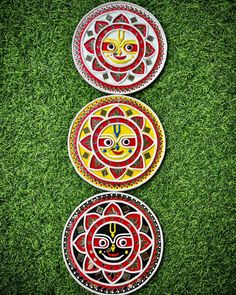 three decorative plates sitting on top of green grass