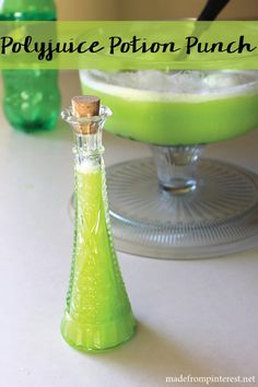 a green bottle sitting on top of a table next to a plate with food in it