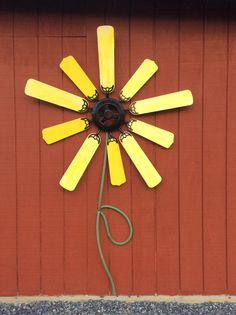 a yellow and black clock on the side of a red building with a green cord attached to it