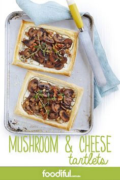 mushroom and cheese tartles on a baking sheet with a fork next to it