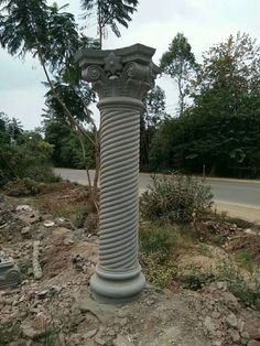 a stone pillar sitting on the side of a road