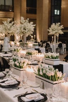 the table is set with white flowers and candles for an elegant wedding reception at the grand america hotel