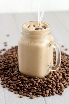 a glass jar filled with coffee beans on top of a table