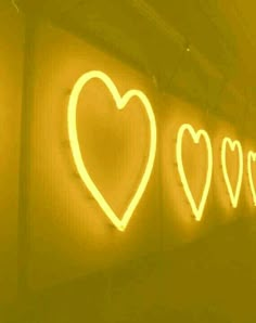 three neon hearts are on the wall next to each other