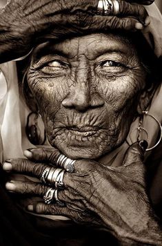 an old woman with wrinkles and rings on her head is posing for the camera