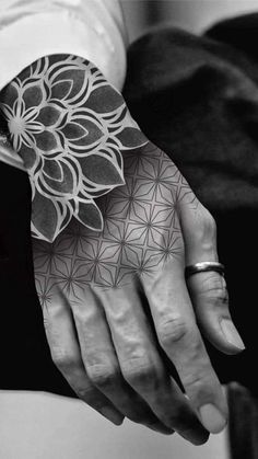 black and white photograph of a person's hand with an intricate design on it