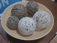 four balls of yarn are on a plate