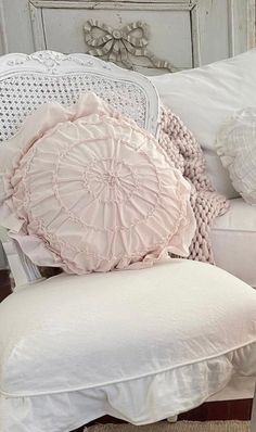 a white chair with some pillows on top of it