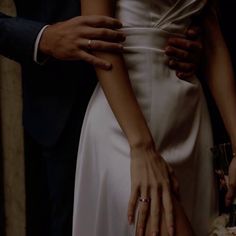 the bride and groom are holding each other's hands