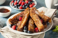 french toast on a plate with berries and blueberries