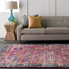 a living room with a couch, lamp and rug