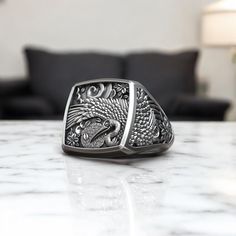 Immerse yourself in the elegance of Japanese tradition with this Stork Bird Flower Traditional Japanese Ornament Signet Ring, meticulously crafted from 925 sterling silver. This stunning ring features a beautifully detailed design of a stork, a symbol of longevity and good fortune in Japanese culture, surrounded by delicate floral patterns that enhance its timeless beauty. Designed for both men and women, this unique statement piece blends nature-inspired motifs with traditional Japanese artistry, making it a sophisticated addition to any outfit. The adjustable band ensures a perfect fit, providing versatility and comfort. Whether you're exploring cultural accessories, celebrating a special occasion, or searching for a meaningful gift, this Stork Bird Flower Ring is an exceptional choice. Symbolic Carved Jewelry For Formal Occasions, Silver Carved Rectangular Jewelry, Carved Silver Rectangular Jewelry, Silver Rectangular Carved Jewelry, Carved Rectangular Silver Jewelry, Ceremonial Hallmarked Jewelry, Cultural Accessories, Japanese Ornament, Stork Bird