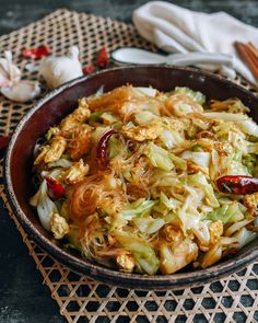 a bowl filled with food sitting on top of a table next to chopsticks