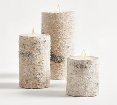 three white candles sitting next to each other