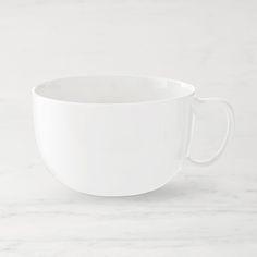 a white cup sitting on top of a marble counter