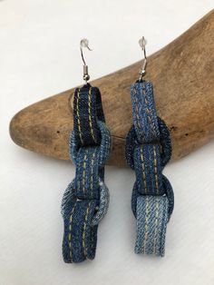 pair of denim earrings with yellow stitching on them