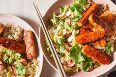 two plates filled with food and chopsticks on top of a table next to each other