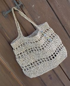 Handmade crocheted raffia bag in a gorgeous natural straw colour. Each bag has a unique beaded charm attached near the handle, each charm is different and made by me. The bag also has an attached internal key fob so you can rest assured that your keys are always safe. Great as a beach bag, shopper or everyday tote. Approx. size 40 x 32cm The bag is made using eco friendly cellulose raffia, its super strong and will last years if treated with respect, please don't store in in a humid environment. Eco-friendly Macrame Straw Bag For Vacation, Cream Jute Straw Bag Handwoven, Handwoven Cream Jute Straw Bag, Cream Handwoven Jute Straw Bag, Natural Macrame Beach Bag For Everyday Use, Eco-friendly Crochet Straw Tote Bag, Natural Macrame Tote Beach Bag, Natural Macrame Beach Bag Tote, Natural Jute Crochet Tote Bag